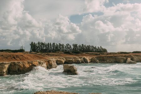 coastline of mediterranean sea against sky with white cloudsの写真素材