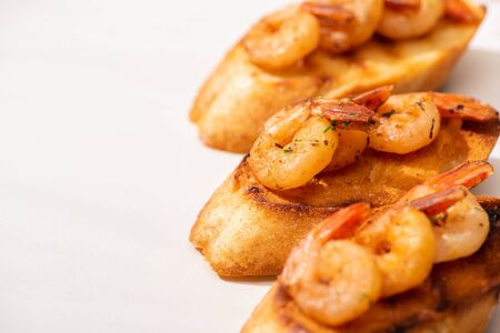close up view of canape with toast bread and fried shrimps on white backgroundの写真素材