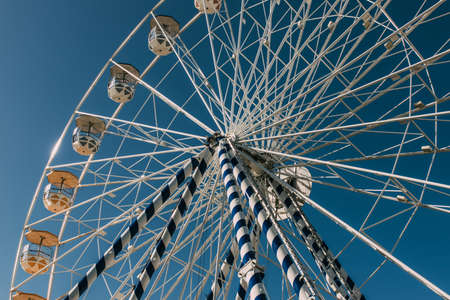low angle view of ferris wheel against blue sky in summertimeの写真素材