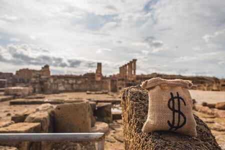 money bag with dollar sign near ancient House of Theseus ruins