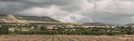 panoramic shot of green trees and plants near houses in mountainsの写真素材