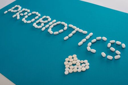 probiotics lettering and heart made of pills on blue and white backgroundの写真素材