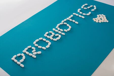 probiotics lettering and heart made of pills on blue and white backgroundの写真素材
