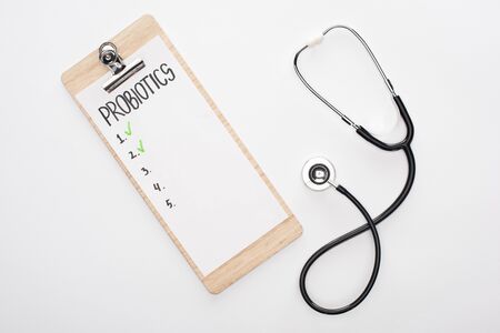 top view of clipboard with probiotics empty list and stethoscope on white backgroundの写真素材