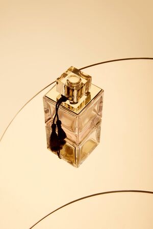 High angle view of perfume bottle on round beige mirror surfaceの写真素材