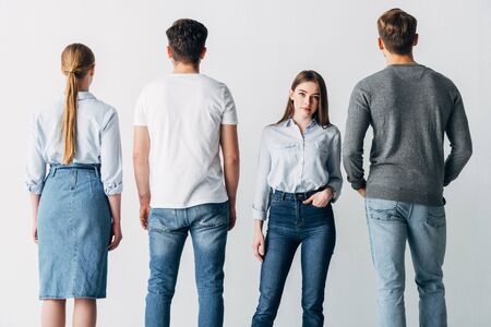 Attractive employee with hand in pocket looking at camera near candidatesの写真素材