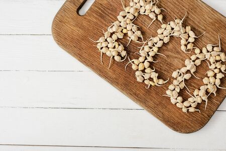 top view of word eco made of sprouts on cutting board on white wooden surfaceの写真素材