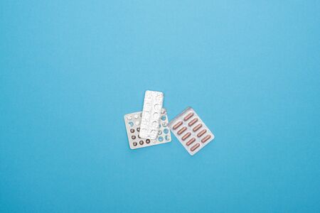 top view of pills in blister packs on blue background