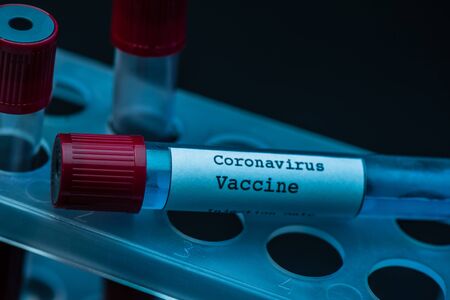 Test tube rack with coronavirus vaccine on dark backgroundの写真素材