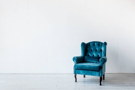 blue and comfortable armchair near white wall in living roomの写真素材