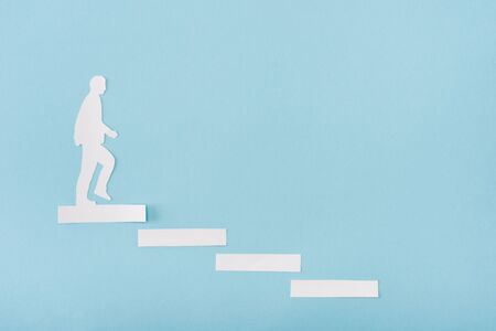 Top view of paper man on career ladder on blue backgroundの写真素材