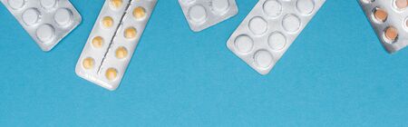 top view of pills in blister packs on blue background, horizontal imageの写真素材