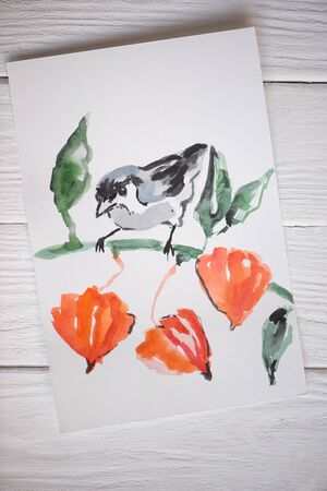 Top view of paper with Japanese painting with bird on branch on wooden backgroundの写真素材