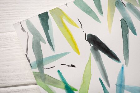 Top view of paper with Japanese painting with multicolored leaves on wooden background