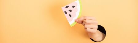 panoramic shot of woman holding paper watermelon on orangeの写真素材