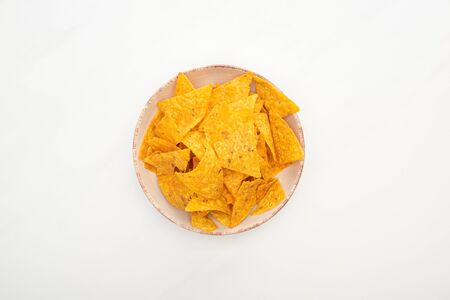 top view of crunchy corn nachos in bowl on white backgroundの写真素材