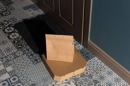 High angle view of pizza boxes and package on floor near door in entryway
