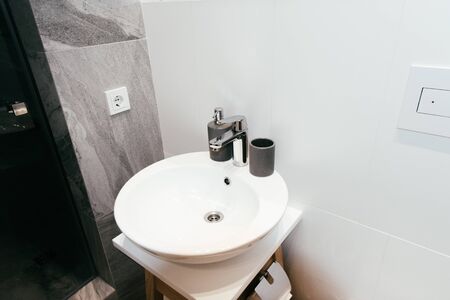 modern interior of bathroom with white washbasin and soap dispenserの写真素材