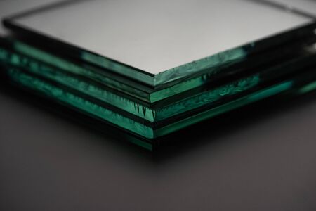 close up view of mirror pieces in stack on dark backgroundの写真素材