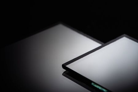 close up view of square mirror pieces in stack on blackの写真素材