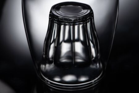 close up view of shot glass in wine glass in darkの写真素材