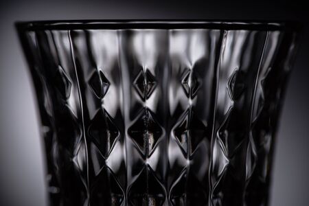 close up view of empty faceted shot glass on dark backgroundの写真素材