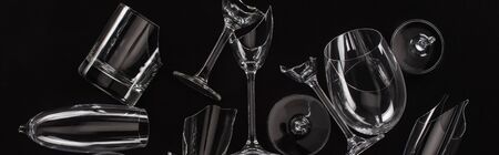 top view of broken sharp transparent glasses isolated on black, panoramic crop