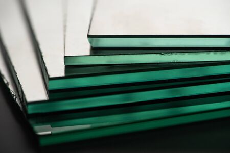 close up view of mirror pieces in stack on dark backgroundの写真素材