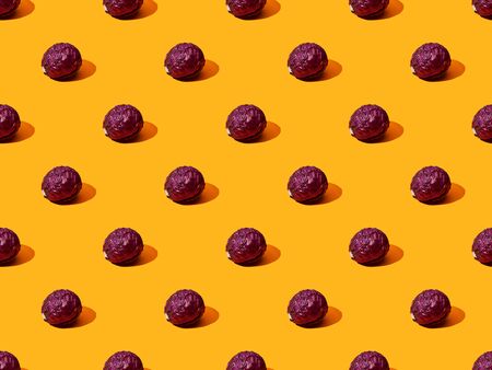 whole ripe red cabbage on orange colorful background, seamless pattern