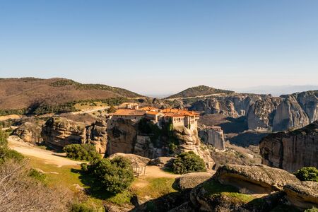 sunshine on historical monastery on rock formations in meteoraの写真素材