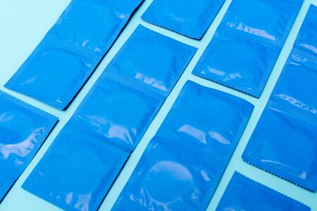 packs with contraceptive condoms isolated on blueの写真素材