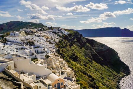 white houses near aegean sea against sky with clouds in greeceの写真素材