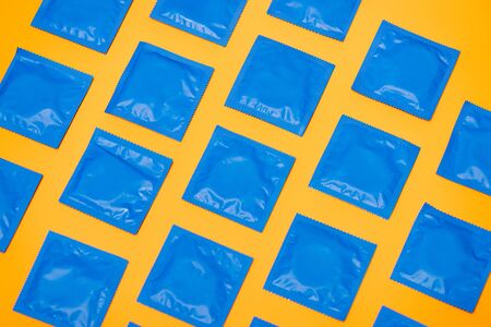 top view of blue packs with condoms isolated on orangeの写真素材