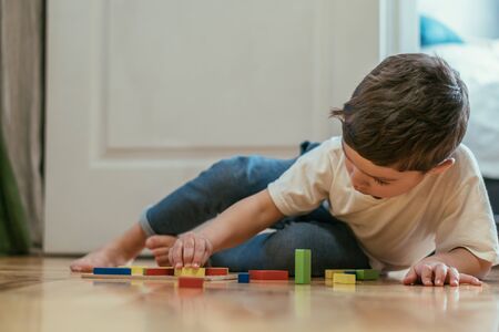 selective focus of cute toddler kid playing with toys on floorの写真素材