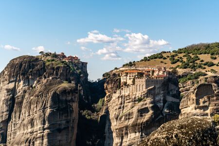 orthodox monasteries on rock formations near mountains in meteora