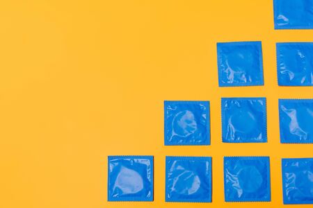 top view of condoms isolated on orange with copy space