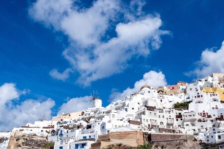 low angle view of white houses near windmill in greeceの写真素材