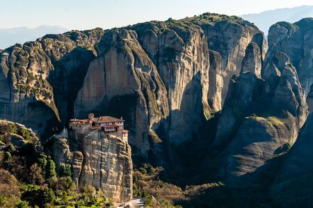 sunlight on rock formations with monastery in meteora