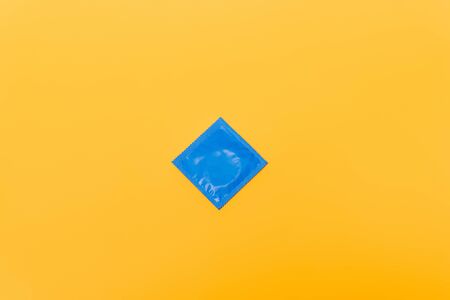 top view of blue pack with condom isolated on orangeの写真素材