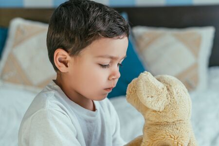 cute toddler boy looking at soft toyの写真素材