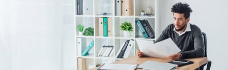 Panoramic crop of african american businessman working with documents in office