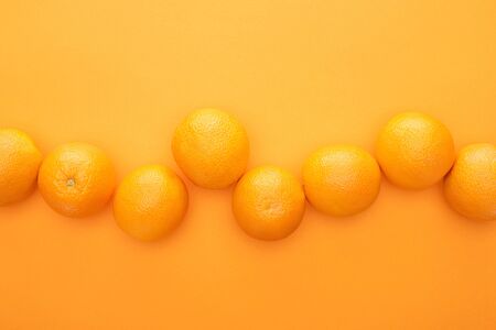 top view of ripe juicy whole oranges on colorful background with copy space