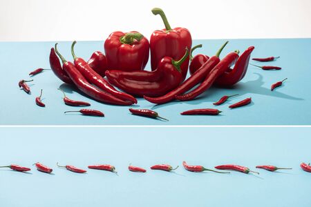 collage of fresh red bell peppers and chili on blue surface on white background