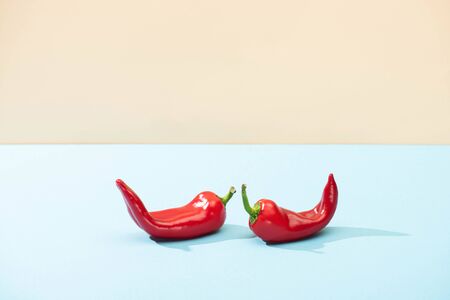 fresh red chili peppers on blue surface isolated on beigeの写真素材