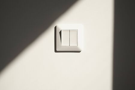 sunshine on white switch on wall in apartmentの写真素材