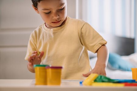 selective focus of adorable child playing with colorful plasticineの写真素材