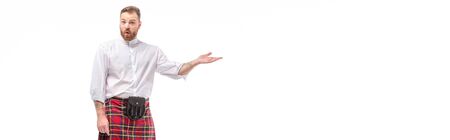 surprised Scottish redhead bearded man in red tartan kilt pointing with hand isolated on white, website headerの写真素材