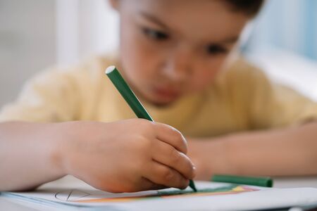 selective focus of cute, attentive child drawing with fel-tip pen