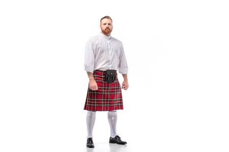 Scottish redhead bearded man in red tartan kilt on white backgroundの写真素材