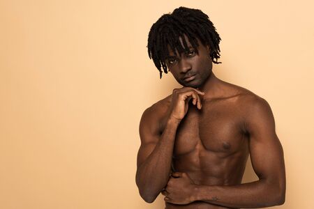 handsome african american shirtless man on beigeの写真素材